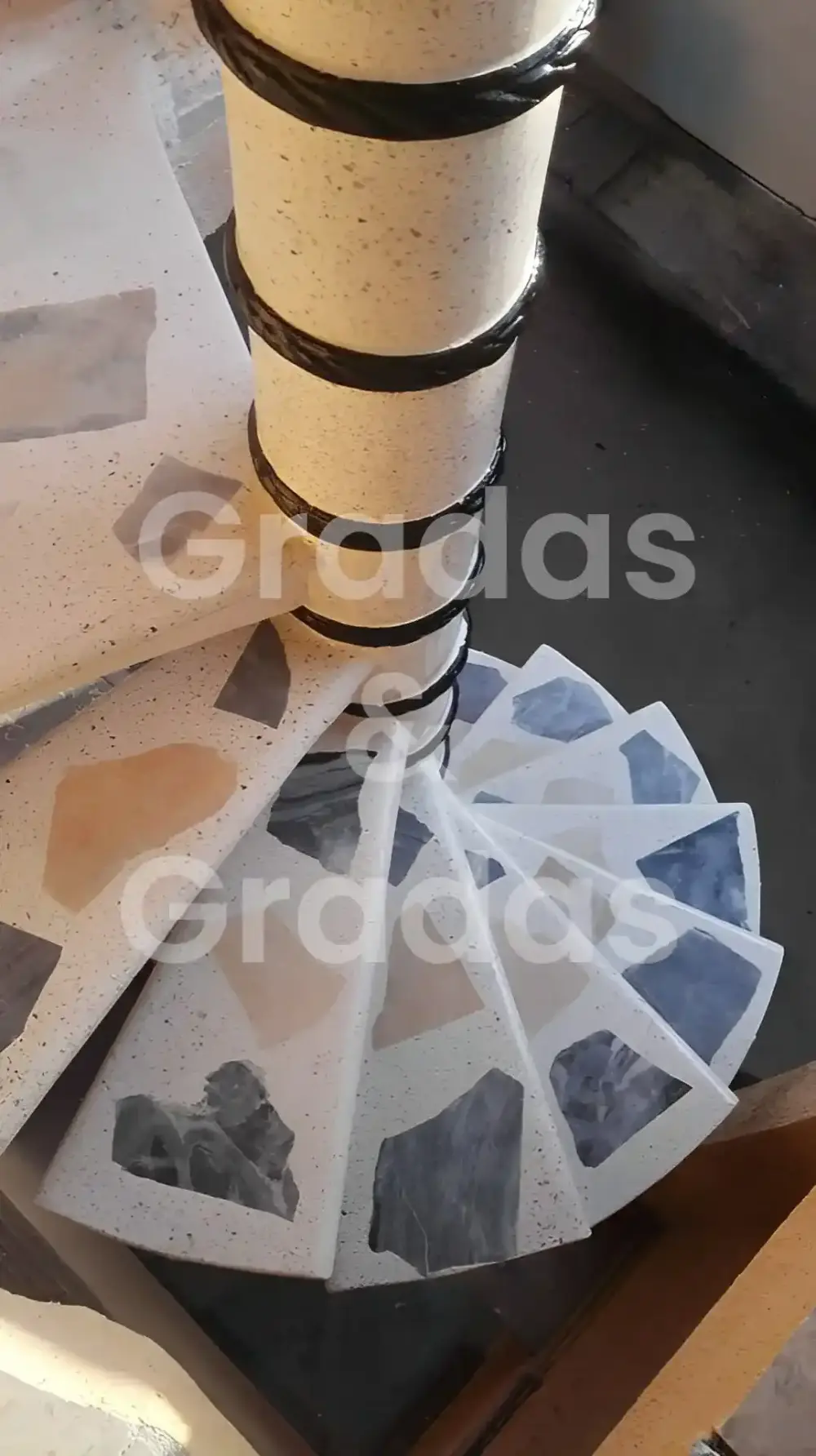 Vista superior de peldaños de una escalera caracol con incrustaciones de piedra