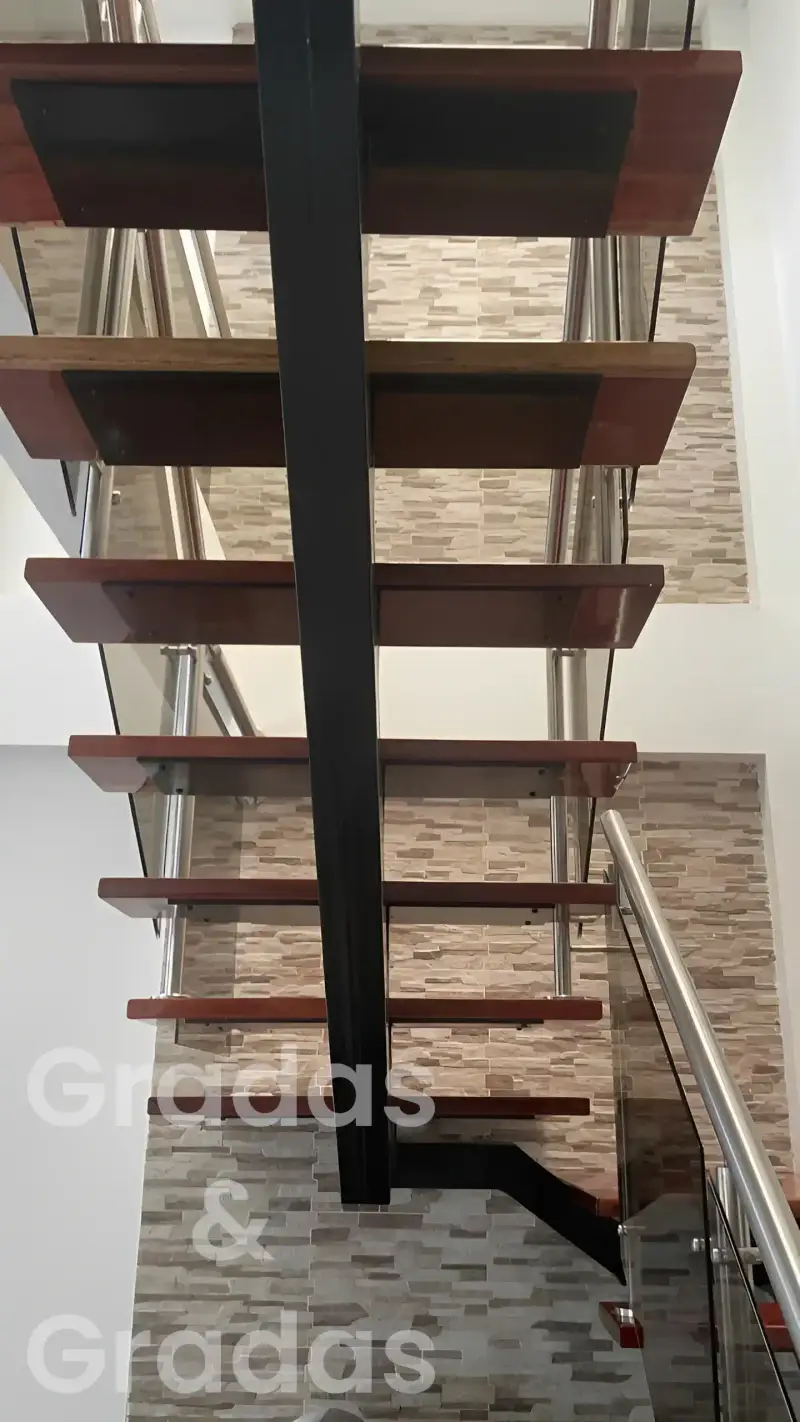 Grada con pasos de madera y pasamanos metálico, vista lateral